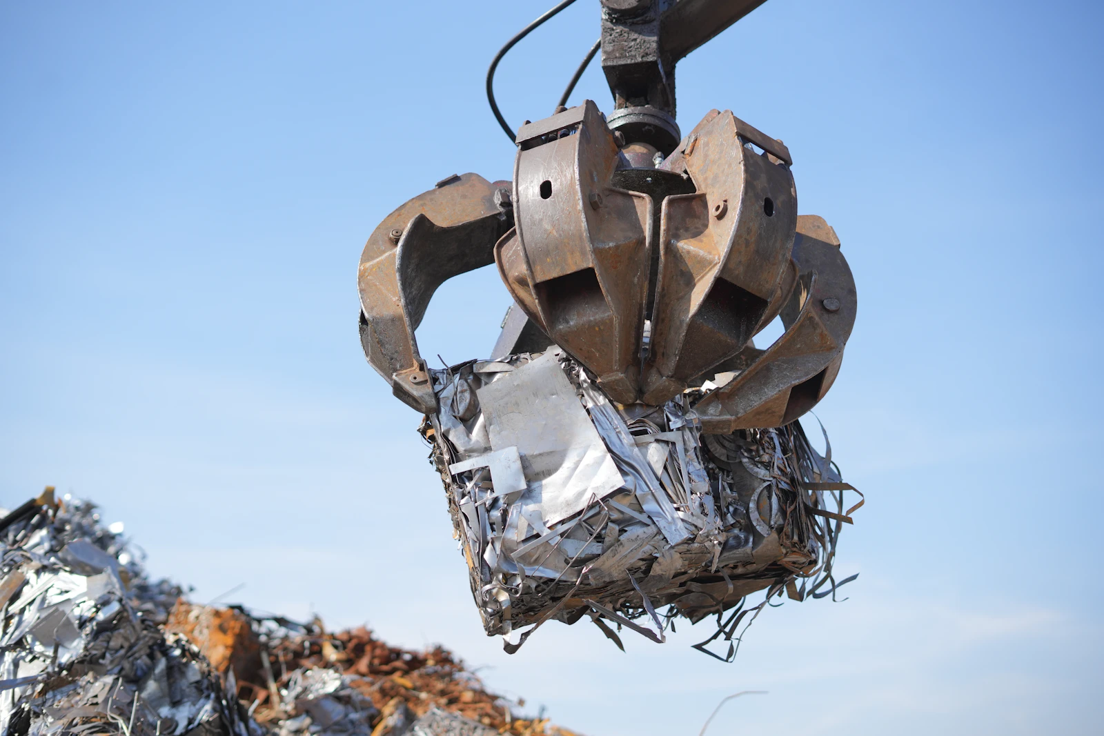 Pressed iron scrap bale lifted through the air at a scrap yard